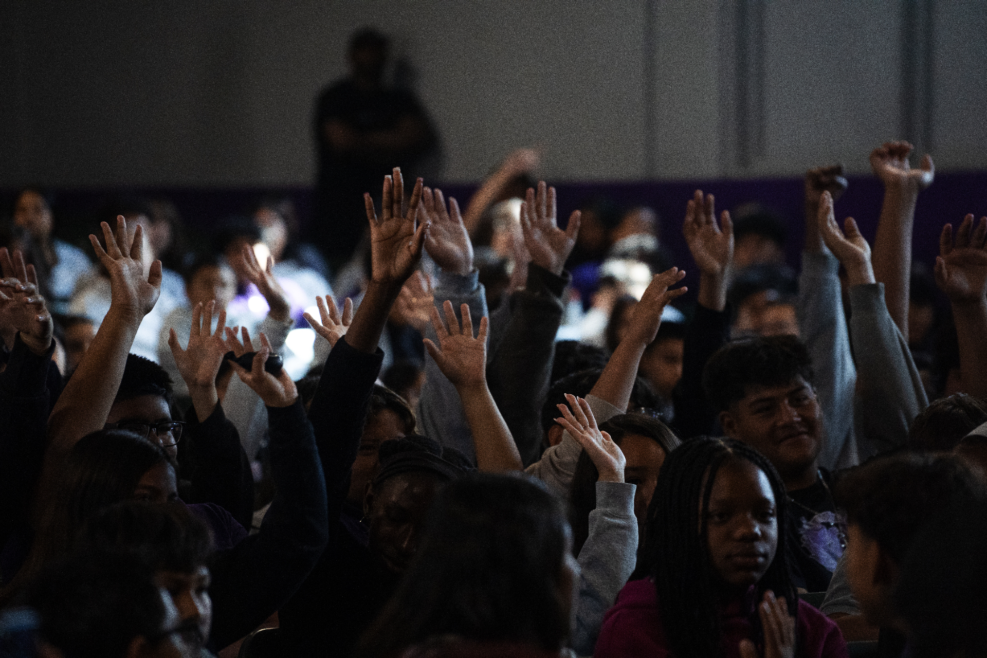Youth with hands raised at a community event